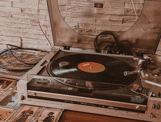 Sepia-toned photo of turntable on table against a brick wall